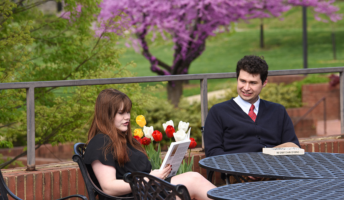 Students sitting outside reading philosophy books